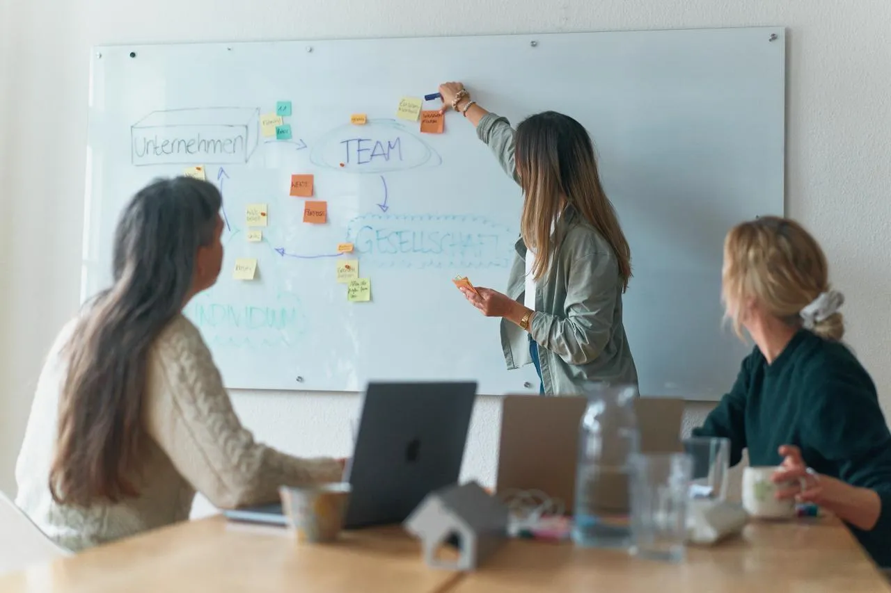 Leonie Strohm moderiert einen Teamworkshop am Whiteboard